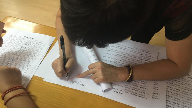 在文件上簽字（網絡圖片）