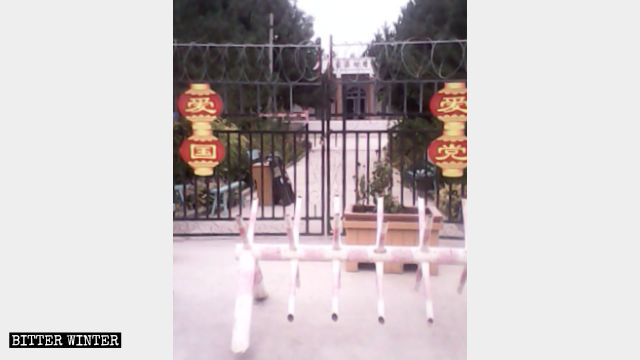 安集海村清真寺大门被锁，大门挂着「爱党」「爱国」的红灯笼，门前有拦车路障
