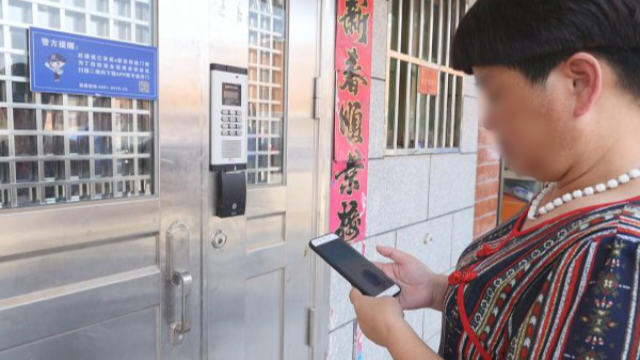 住戶正在使用手機App開智能門鎖(網絡圖片) 住戶正在使用手機App開智能門鎖(網絡圖片)