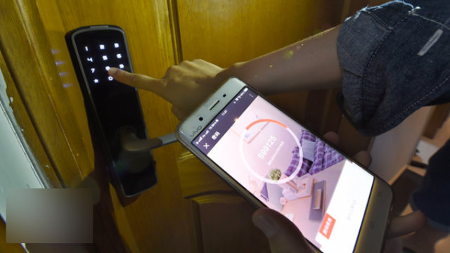 工人正在用手機App測試智能門鎖(網絡圖片) 工人正在用手機App測試智能門鎖(網絡圖片)