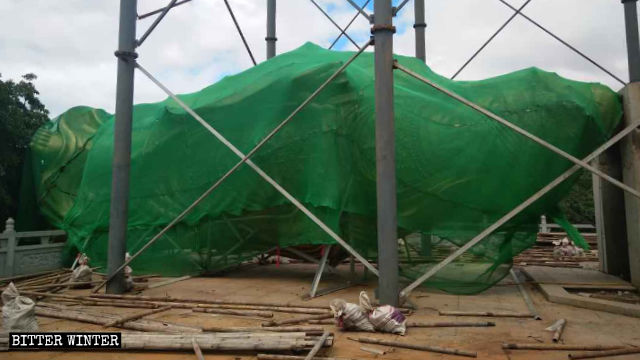 被拆後的觀音像平躺在地上用綠網蓋住 被拆後的觀音像平躺在地上用綠網蓋住