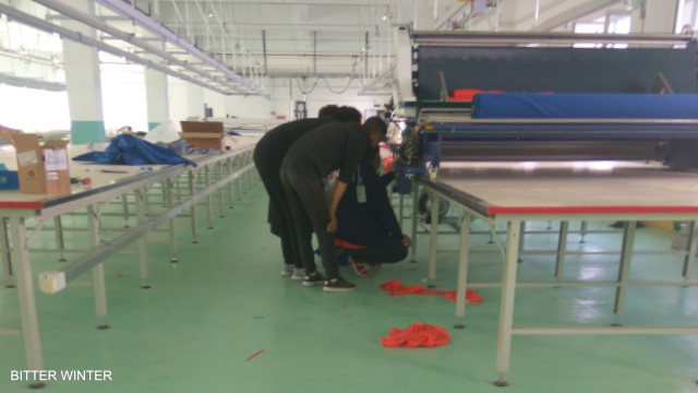 在新疆伊宁市教育转化营内人们被强制劳役、从事「合适工作」的其中一个厂房内，工人正在调试机器。