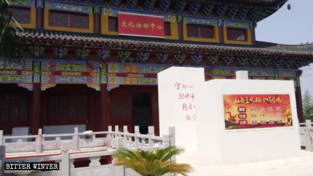 「大雄寶殿」被改成「文化活動中心」,殿前的香爐被封,貼上社會主義核心價值觀的標語 「大雄寶殿」被改成「文化活動中心」,殿前的香爐被封,貼上社會主義核心價值觀的標語